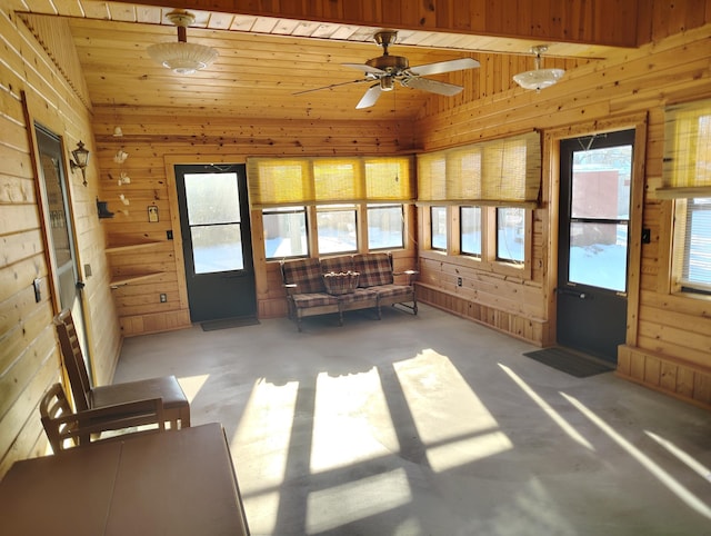 unfurnished sunroom featuring vaulted ceiling, wood ceiling, and ceiling fan