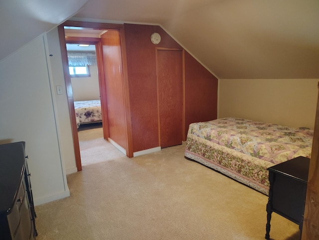 bedroom with lofted ceiling, baseboards, and light carpet