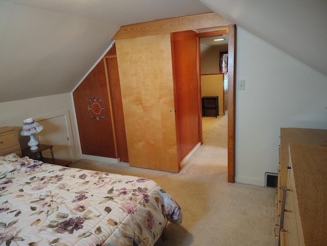 bedroom featuring visible vents, light carpet, baseboards, and vaulted ceiling