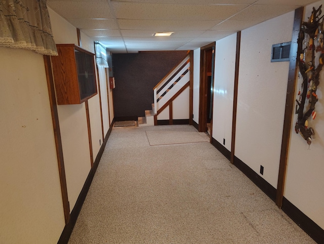 corridor featuring light carpet, stairway, baseboards, and a drop ceiling