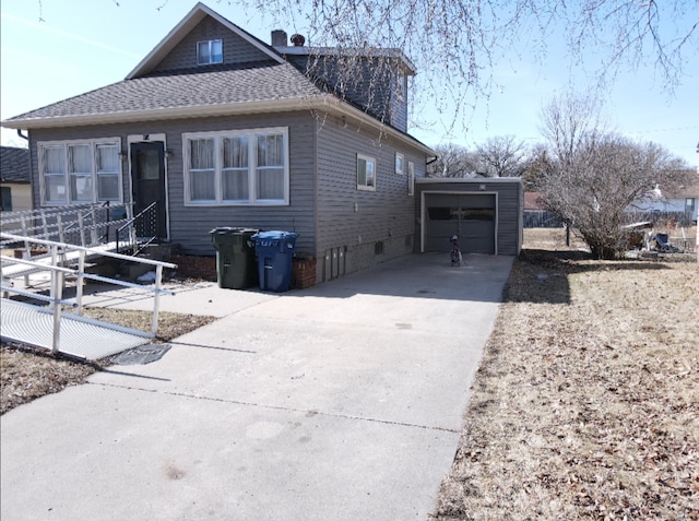 view of front of home featuring roof with shingles, concrete driveway, a chimney, and entry steps