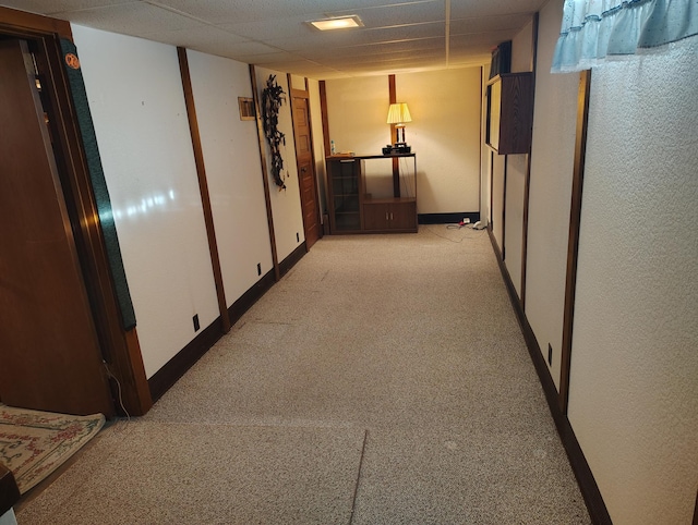 hall with baseboards and light colored carpet