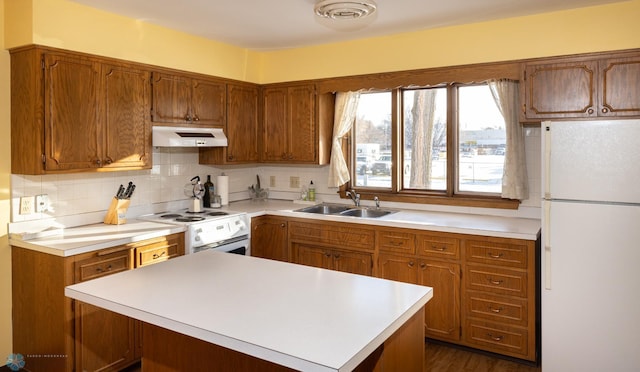 kitchen with white appliances, backsplash, dark wood-type flooring, and sink