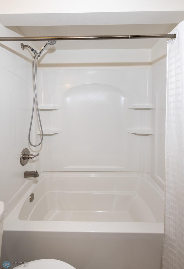 bathroom featuring shower / bath combination with curtain and toilet