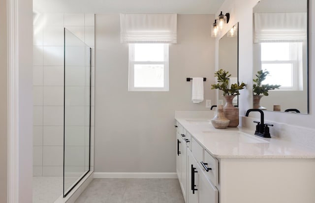 bathroom with a shower, tile patterned flooring, and vanity