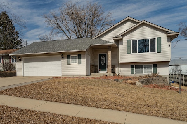 tri-level home featuring concrete driveway, a garage, and a shingled roof