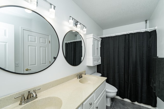 bathroom featuring a textured ceiling, tile patterned floors, toilet, and a sink