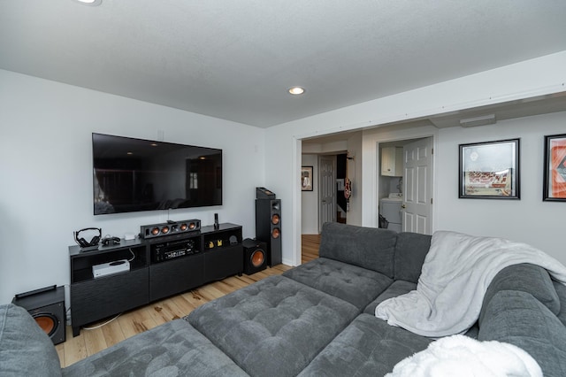 living area featuring recessed lighting, washer / dryer, and light wood finished floors