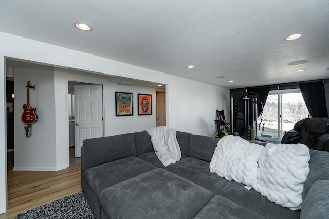 living area with recessed lighting, light wood-style flooring, and a textured ceiling