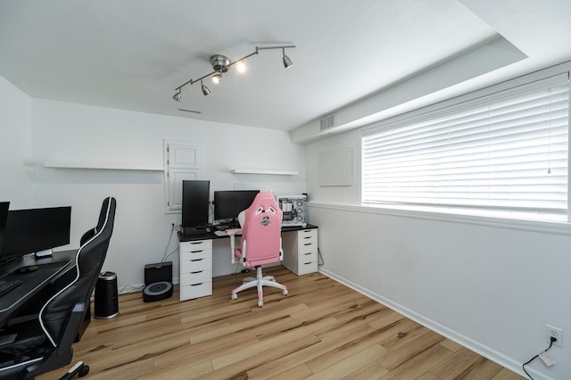 home office with visible vents, baseboards, rail lighting, and light wood finished floors