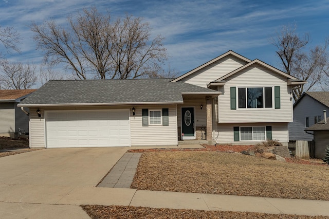 split level home featuring concrete driveway, an attached garage, and roof with shingles