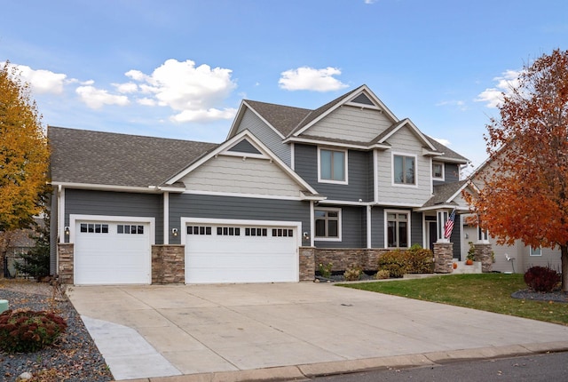 craftsman inspired home with a garage and a front lawn