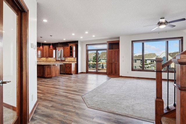 living room featuring a textured ceiling, dark hardwood / wood-style floors, a wealth of natural light, and ceiling fan