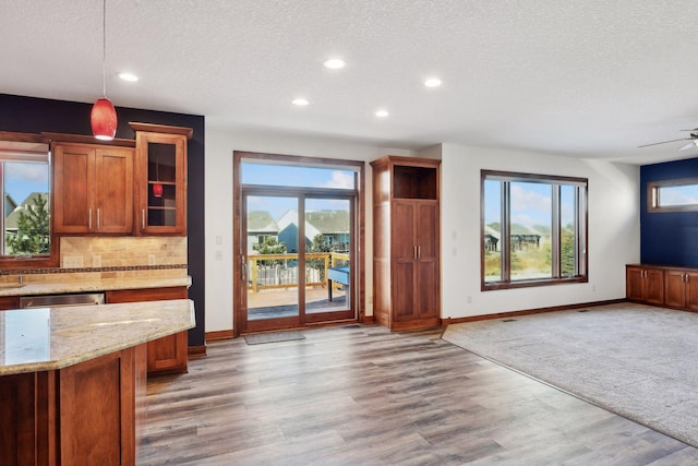 interior space with ceiling fan, light hardwood / wood-style floors, and a textured ceiling