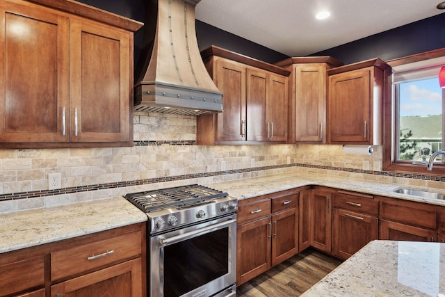 kitchen with custom exhaust hood, sink, dark hardwood / wood-style floors, high end stove, and light stone counters