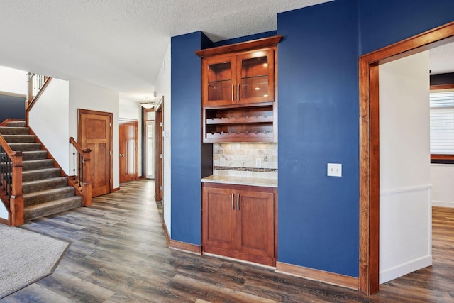 kitchen featuring backsplash, dark hardwood / wood-style flooring, and a textured ceiling