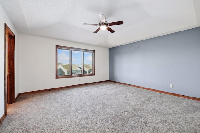 empty room featuring carpet flooring, ceiling fan, a textured ceiling, and a tray ceiling