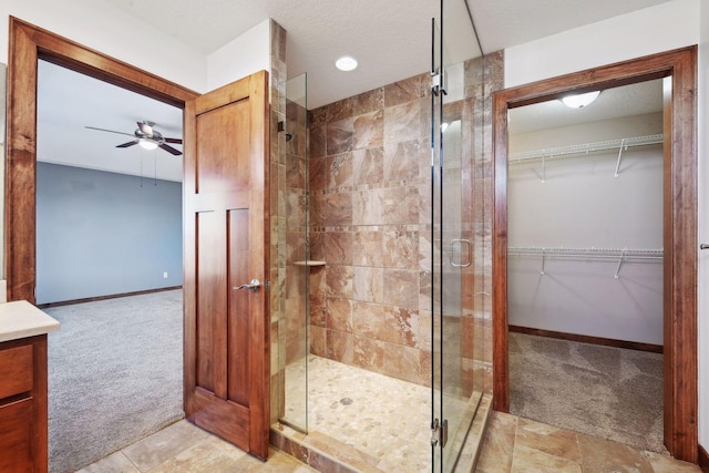 bathroom with ceiling fan, vanity, and walk in shower