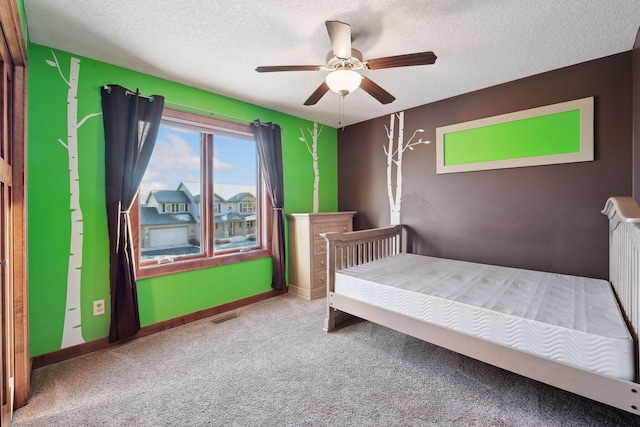 bedroom featuring ceiling fan, carpet floors, and a textured ceiling