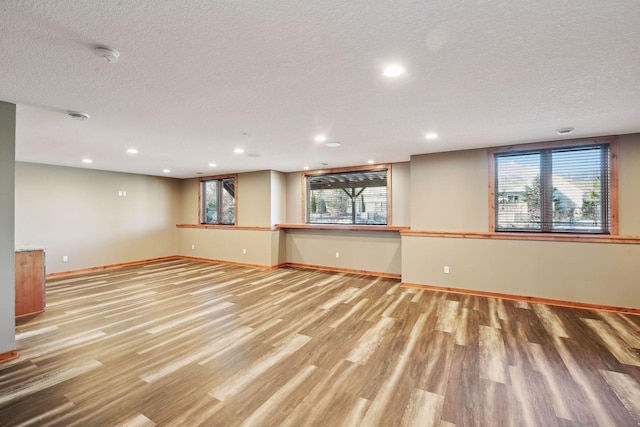 interior space featuring a healthy amount of sunlight, a textured ceiling, and light hardwood / wood-style flooring