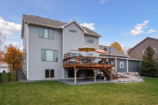 rear view of property featuring a lawn and a deck