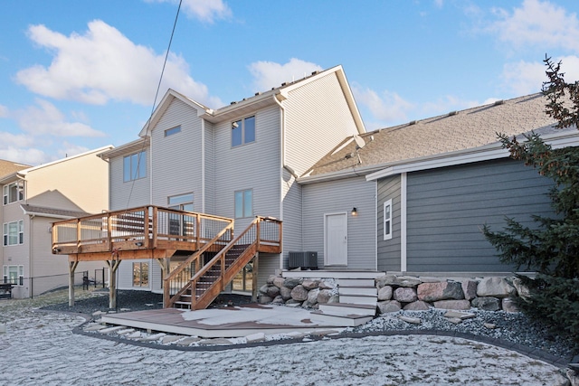 snow covered house with a deck and central AC