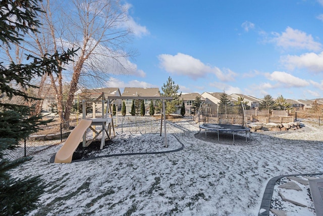 snow covered playground featuring a trampoline