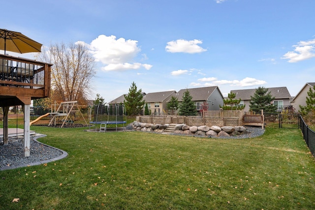 view of yard with a trampoline and a playground