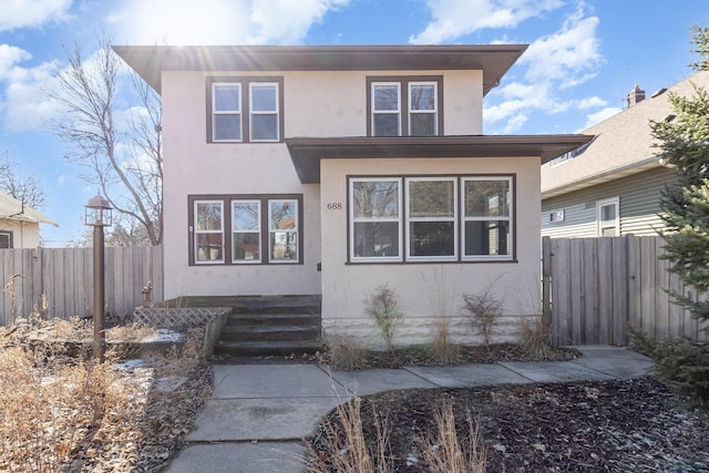 view of front of property featuring fence and stucco siding