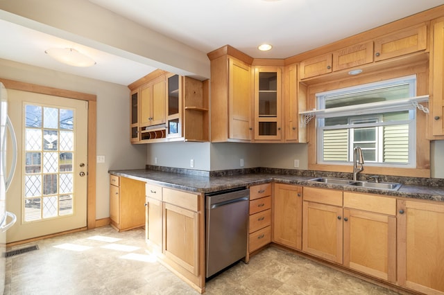 kitchen featuring stainless steel dishwasher, dark countertops, a sink, and glass insert cabinets