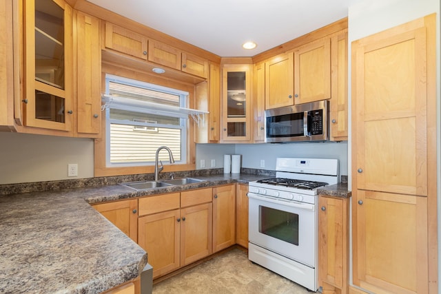 kitchen with white gas stove, stainless steel microwave, a sink, and glass insert cabinets