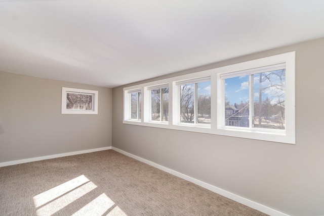 carpeted empty room with baseboards