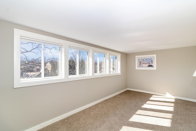 carpeted empty room with baseboards