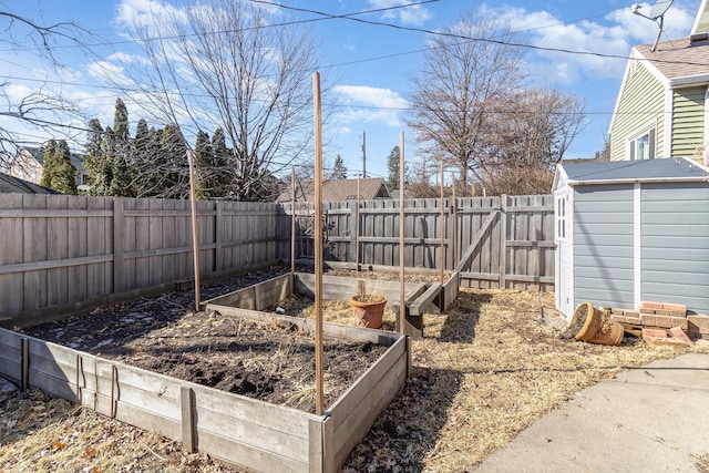 view of yard featuring an outbuilding, a fenced backyard, a vegetable garden, and a shed