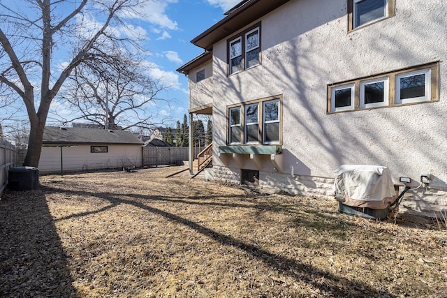 back of house with fence and stucco siding