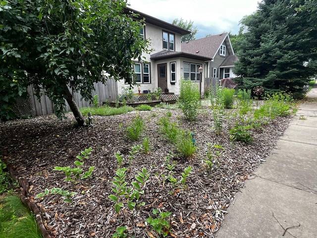 view of front of house with fence and stucco siding