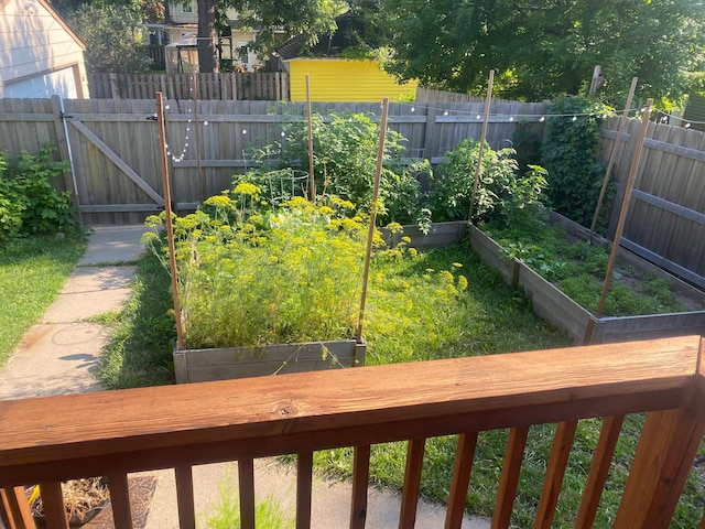 view of yard with a vegetable garden, fence, and a gate