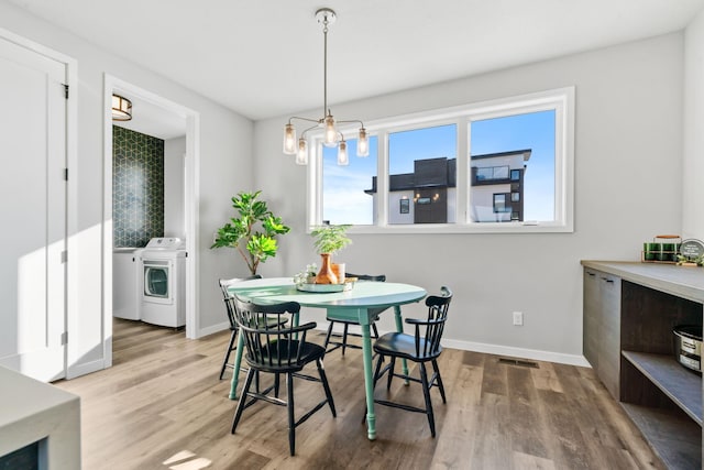 dining room with washer and clothes dryer, wood finished floors, visible vents, and baseboards