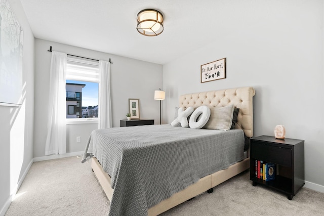 bedroom featuring light colored carpet and baseboards