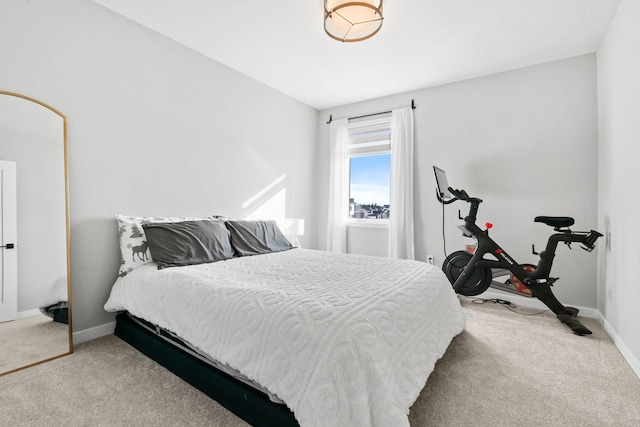 bedroom with light colored carpet and baseboards