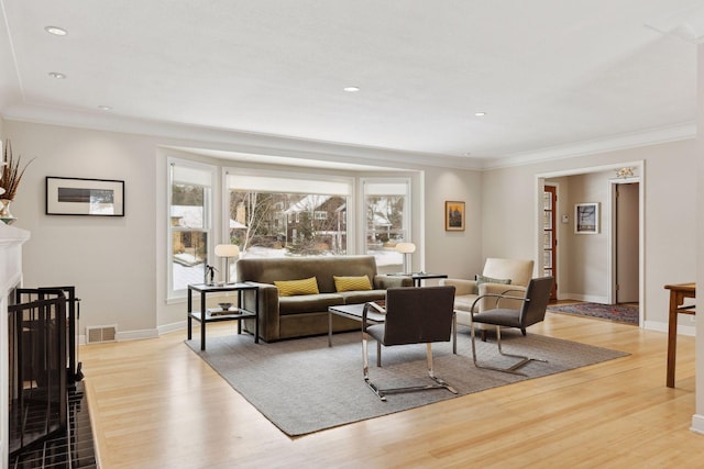 living room with ornamental molding and light hardwood / wood-style floors