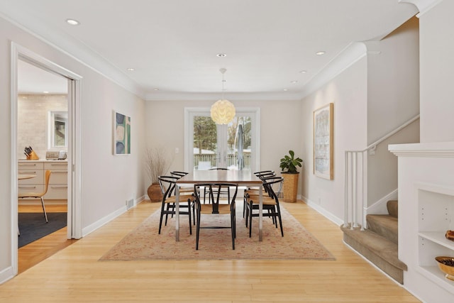 dining space featuring crown molding, a notable chandelier, and light wood-type flooring