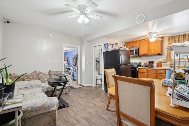 kitchen featuring ceiling fan, black appliances, and light wood-type flooring