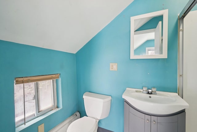 bathroom with vanity, toilet, and lofted ceiling