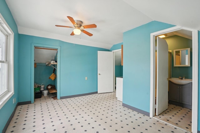 unfurnished bedroom with ceiling fan, vaulted ceiling, a spacious closet, and a closet