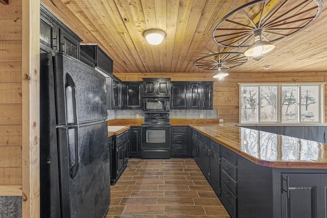 kitchen featuring butcher block counters, wood ceiling, wooden walls, and black appliances