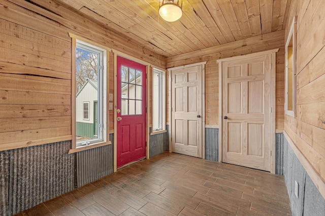 foyer featuring dark hardwood / wood-style flooring, wood ceiling, and wooden walls