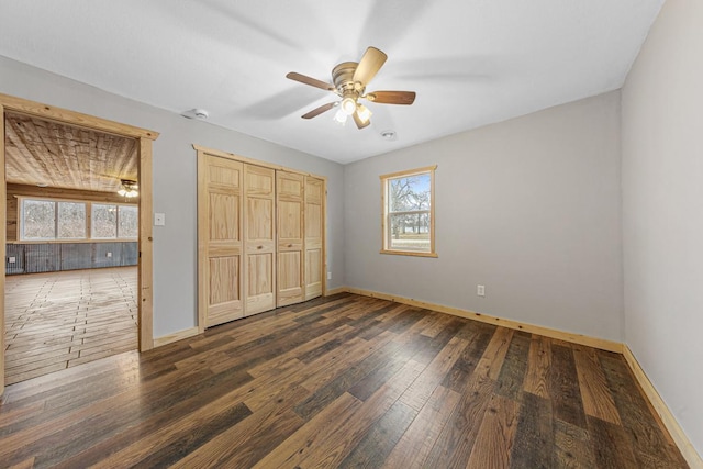 unfurnished bedroom with ceiling fan, a closet, and dark wood-type flooring