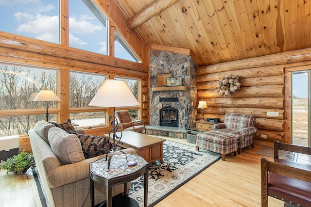 living room featuring beam ceiling, wooden ceiling, a stone fireplace, high vaulted ceiling, and light hardwood / wood-style floors