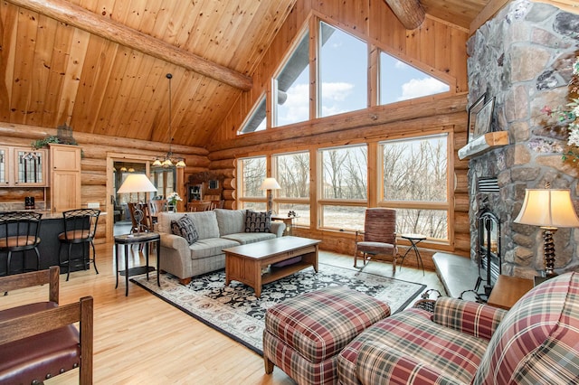 living room with a wealth of natural light, beam ceiling, high vaulted ceiling, and light hardwood / wood-style flooring